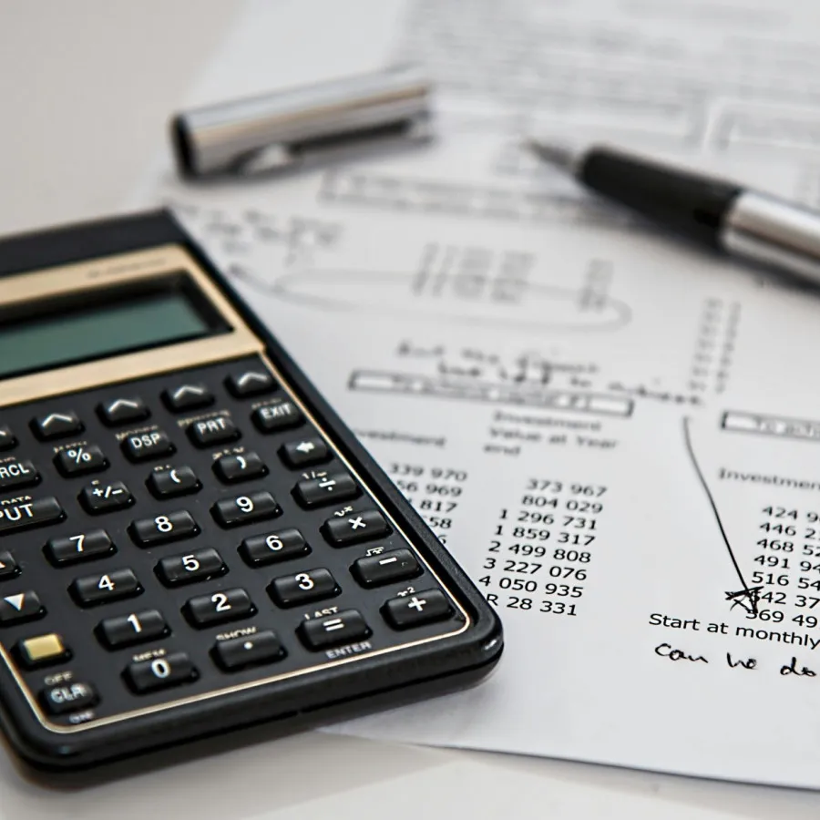 Working through figures on a calculator with financial reports